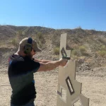 side view of Man shooting gun in open range