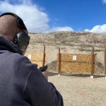 man shooting pistol in open gun range
