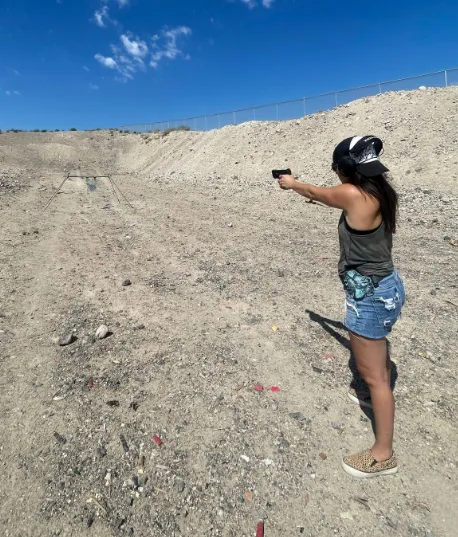 woman shooting pistol in open range