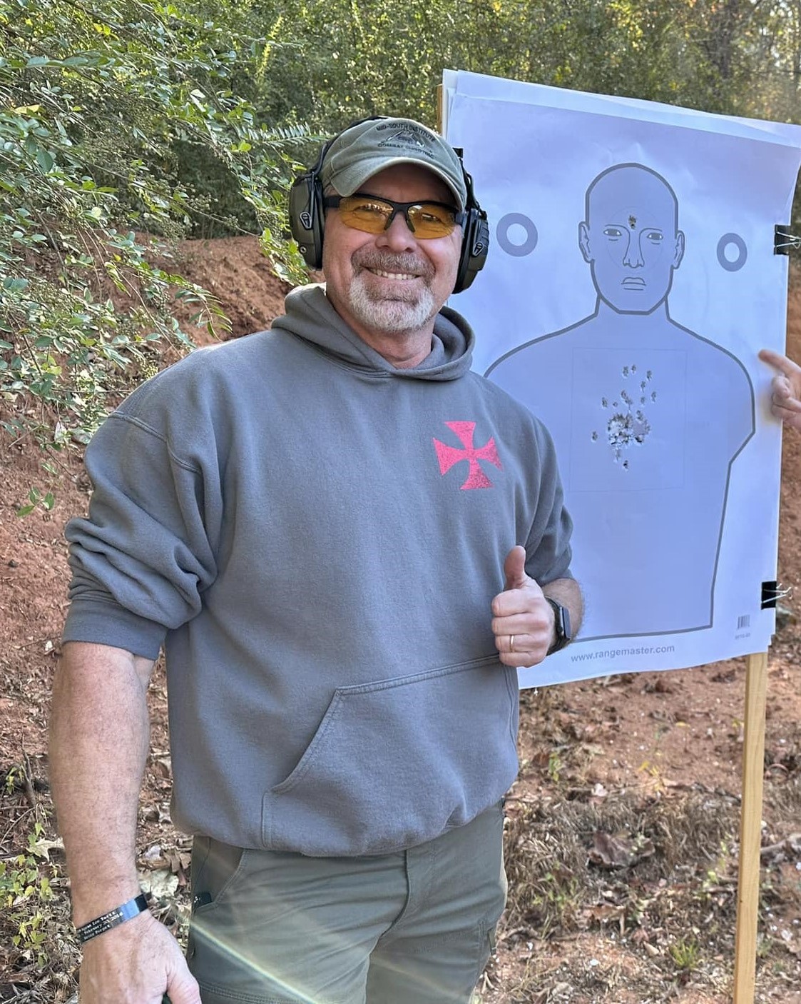 man standing next to gun target