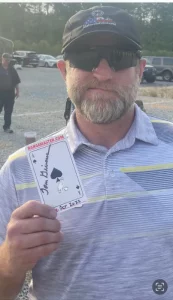 Trainer holding playing card